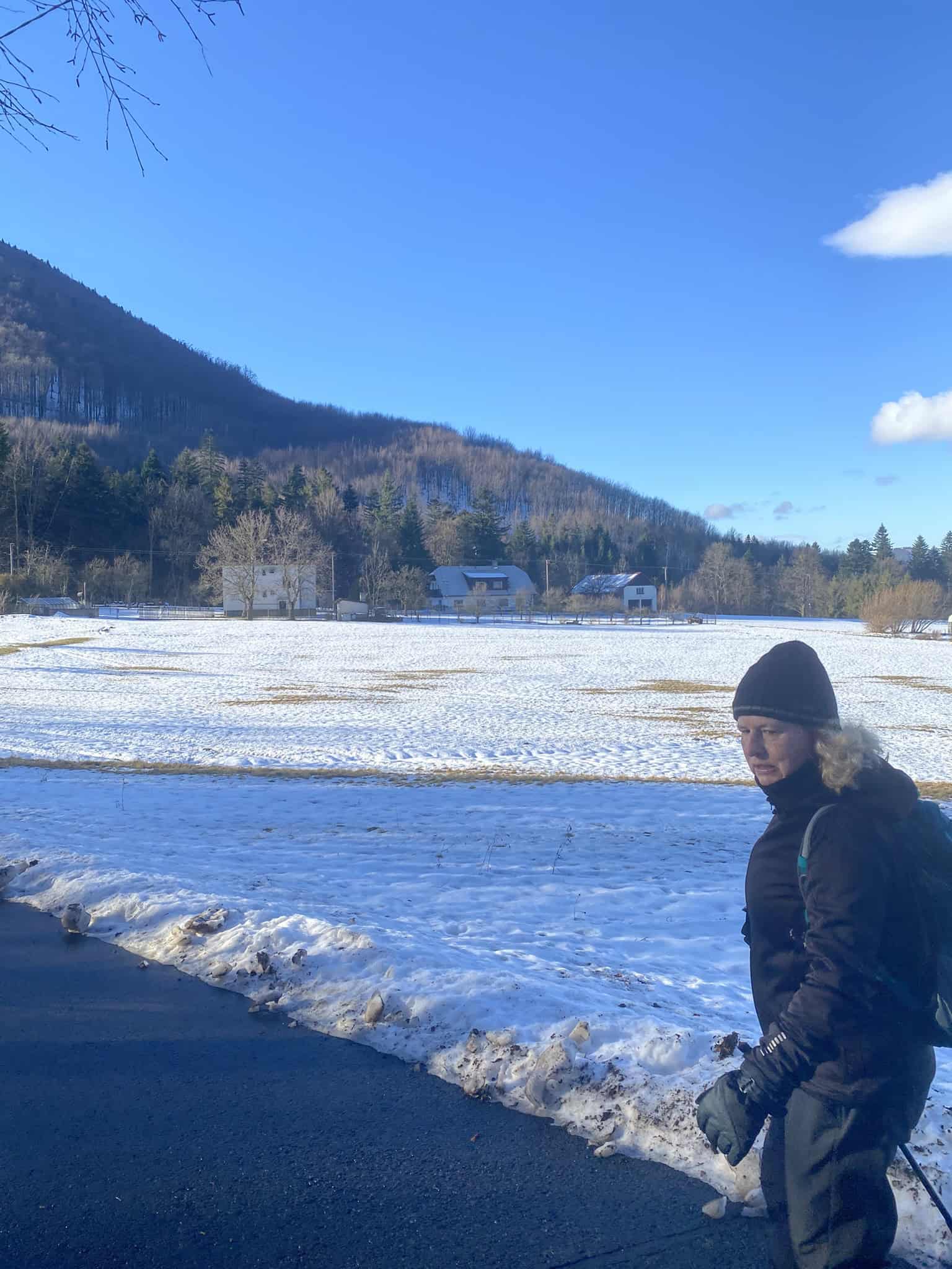 Nástup do hor vede po vymrzlé asfaltce, ale s vidinou prosluněných kopců před námi.