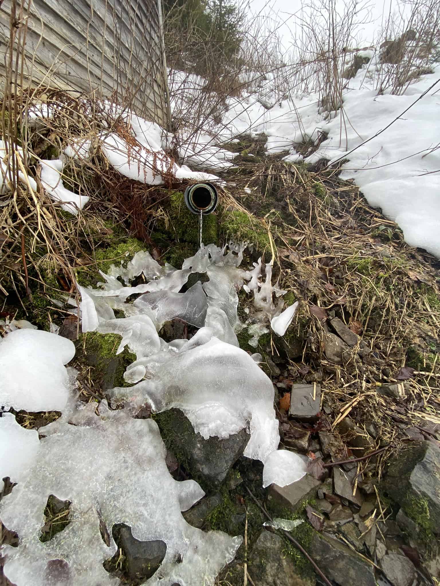 Zima čaruje. Zmrzlý pramen u cesty.