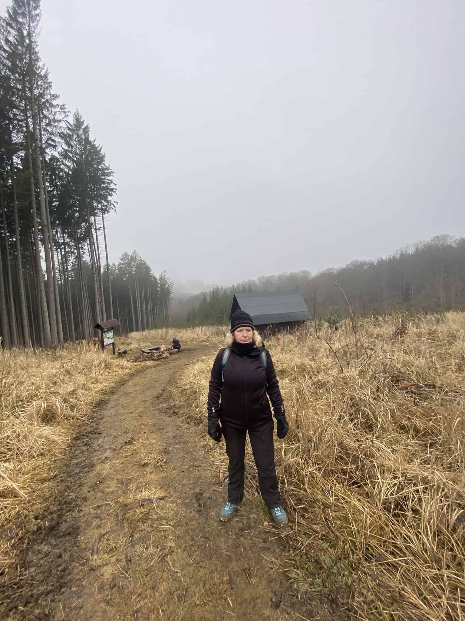 Mlha, bláto a partyzánský srub na horizontu.